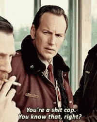 a man in a suit and tie is smoking a cigarette and talking to another man who is smoking a cigarette .
