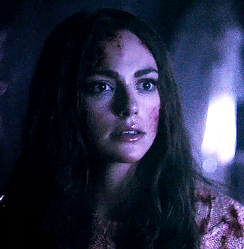 a close up of a woman 's face with blood on her face