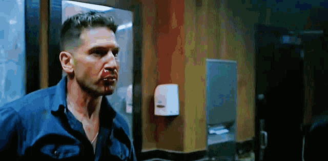 a man with a bloody nose is standing in a room .