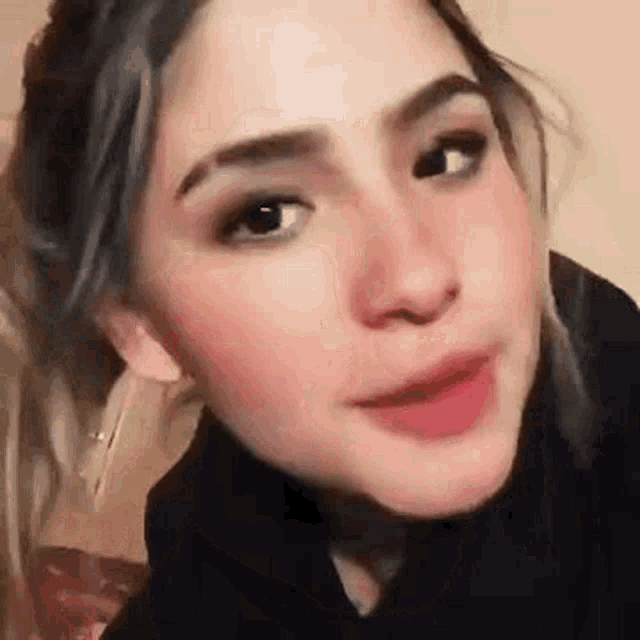 a close up of a woman 's face with her mouth open and looking at the camera .