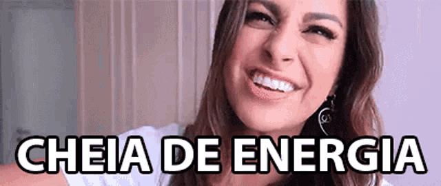 a woman is smiling with the words cheia de energia written above her