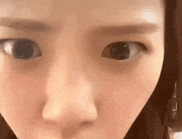 a close up of a woman 's face with her eyes open .