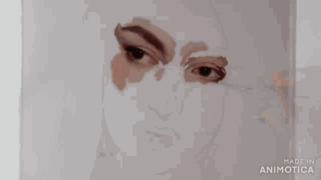 a person is painting a woman 's face with a brush on a piece of paper .