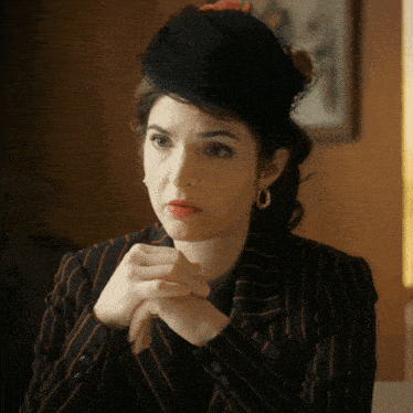 a woman wearing a black hat and a striped jacket