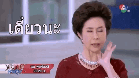 a woman is making a funny face in front of a sign that says ' hong ' on it .