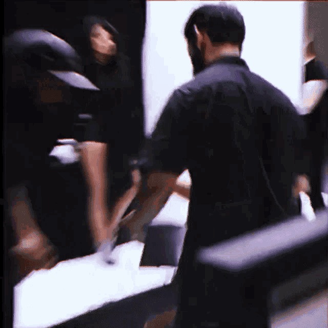 a man in a black shirt stands in a dark room