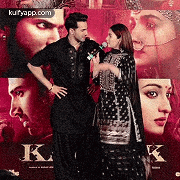 a man and a woman are standing next to each other and talking into a microphone .