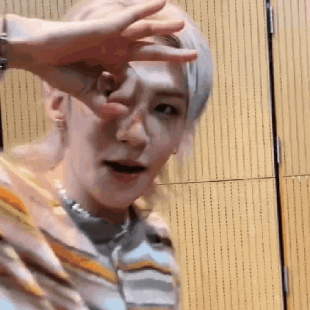 a person is making a funny face with their hand on their face .