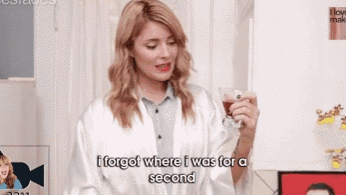 a woman in a white robe is holding a glass of wine and saying `` i forgot where i was for a second ''