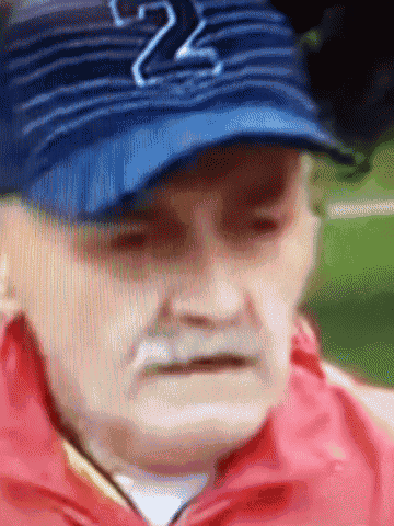 an elderly man wearing a blue hat with the number 22 on it