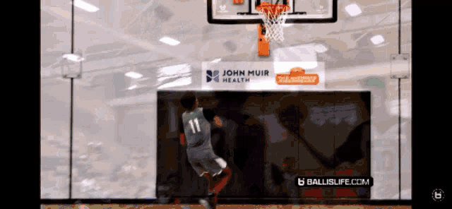 a basketball game is being played in front of a sign for john muir health