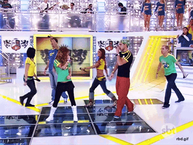 a group of people are dancing on a stage with a sbn logo in the background