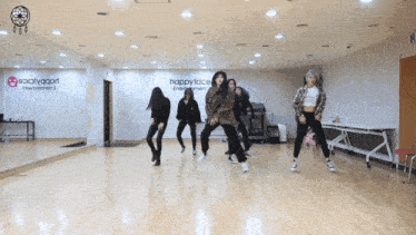a group of women are dancing in front of a happyface entertainment sign