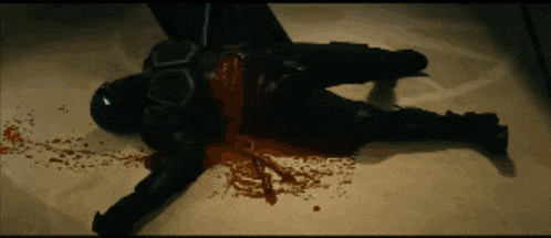 a man is laying on the floor with blood coming out of his pants