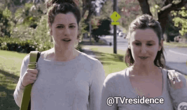 two women walking down a street with the words @tvresidence on the bottom right