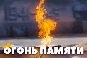 a fire is burning in front of a wall that says ' огонь памяти '