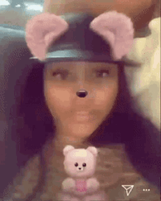 a woman wearing a hat and holding a teddy bear .