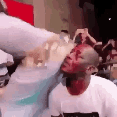 a man with blood on his face is being punched by a woman .