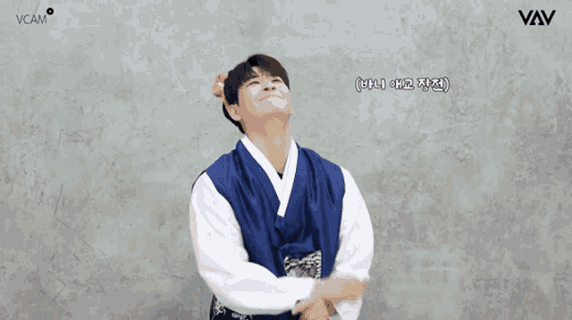 a man in a blue and white kimono with a logo for vcam