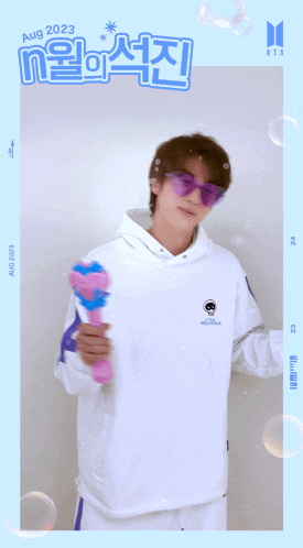 a man in a white hoodie and purple sunglasses is holding a pink bubble gun with the date aug 2023 on the bottom