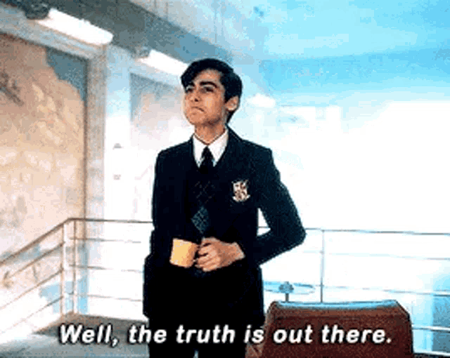 a man in a suit and tie is holding a cup of coffee and saying `` well , the truth is out there '' .