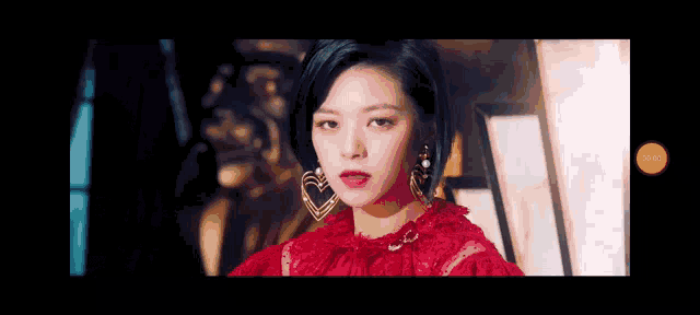 a close up of a woman wearing a red dress and earrings .