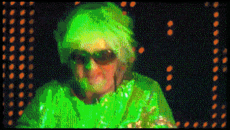 an elderly woman wearing sunglasses and a green top