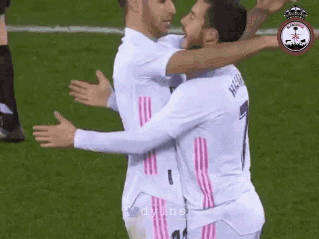 two soccer players are hugging each other on the field