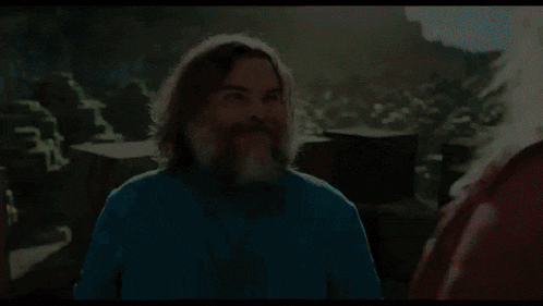 a man with long hair and a beard is wearing a blue shirt