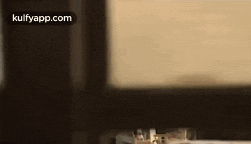 a person is sitting in a chair in front of a window in a room .