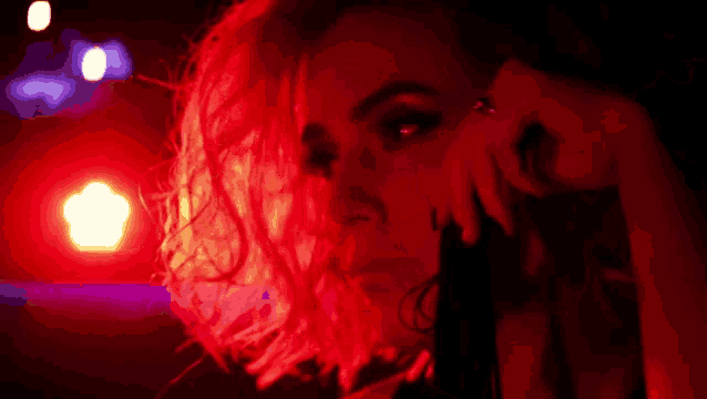 a close up of a woman 's face in a red light .