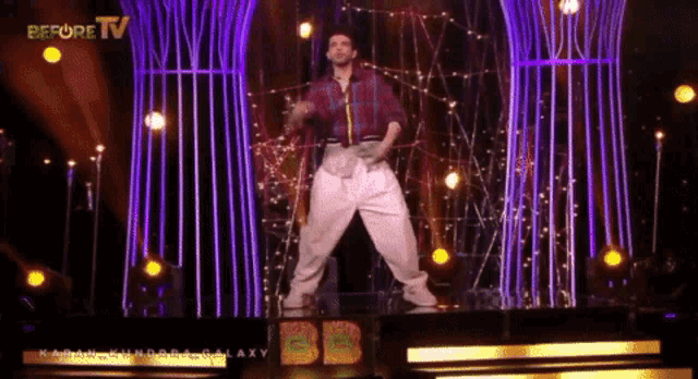 a man is dancing on a stage in front of a sign that says " before tv "