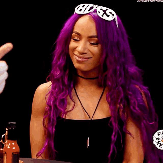 a woman with purple hair is wearing sunglasses with the word boss on them