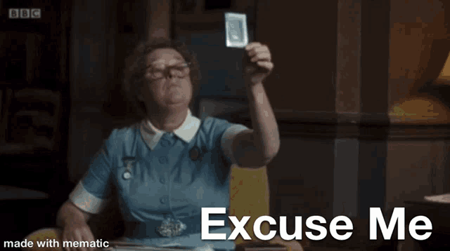 a woman in a blue dress is holding a playing card and the caption excuse me