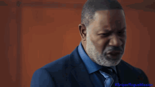 a man in a suit and tie sits at a desk with the name b. beckett on it