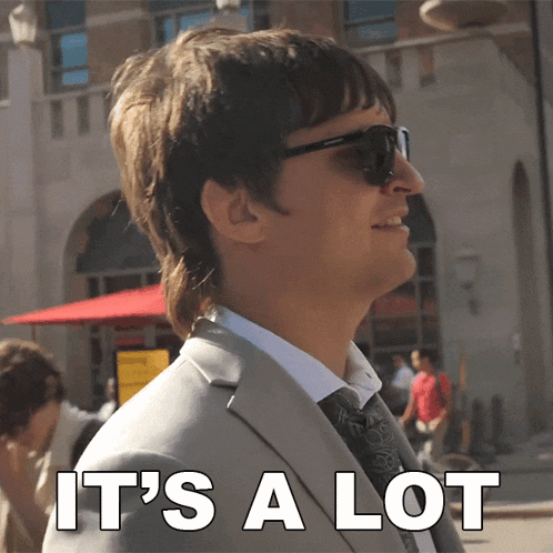 a man in a suit says it 's a lot in white letters