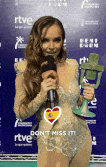 a woman holding a microphone in front of a sign that says beni dorm