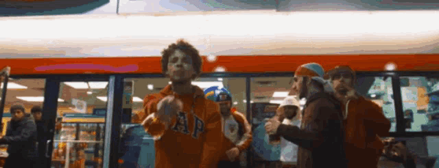 a man wearing an orange gap sweatshirt is dancing