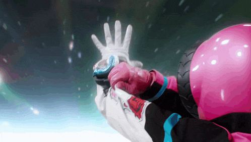 a person wearing a pink helmet and gloves is holding something