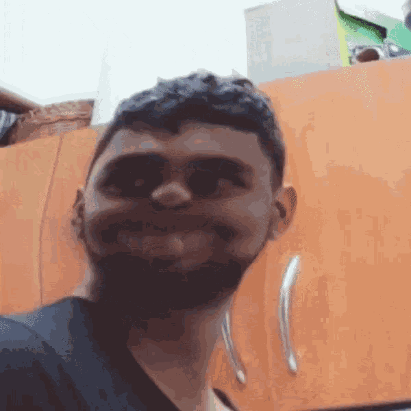 a man with a beard and a black shirt is smiling
