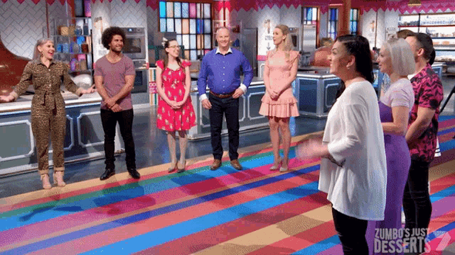 a group of people standing in a kitchen with the words zumbos just desserts on the bottom right