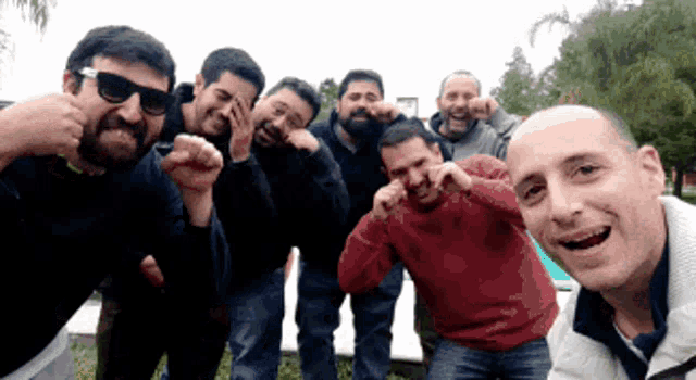 a group of men are posing for a picture and one man is wearing sunglasses