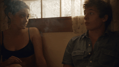 a man and woman are sitting in front of a window