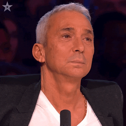 a man is sitting in front of a microphone with a star on his chest