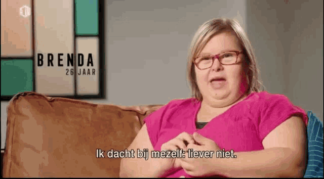 a woman with glasses is sitting on a couch and says brenda 26 jaar ik dacht bij mezelf liever niet .