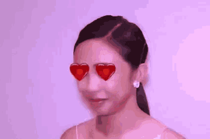 a woman with heart shaped glasses on her eyes is smiling