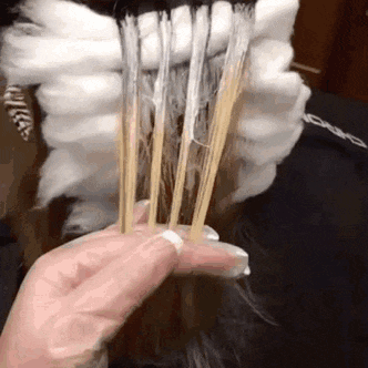 a person is holding a bunch of sticks in front of their face