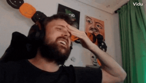 a man with a beard wearing headphones covering his eyes