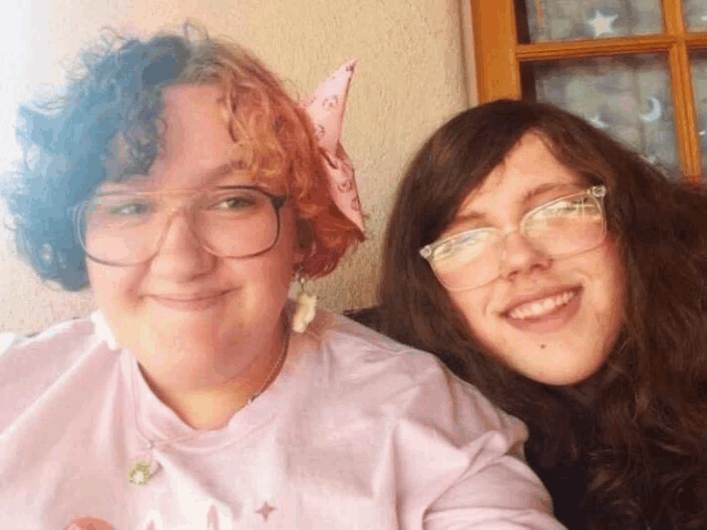 two women wearing glasses are posing for a selfie