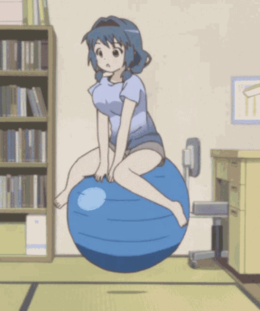 a girl sits on a blue exercise ball in a room